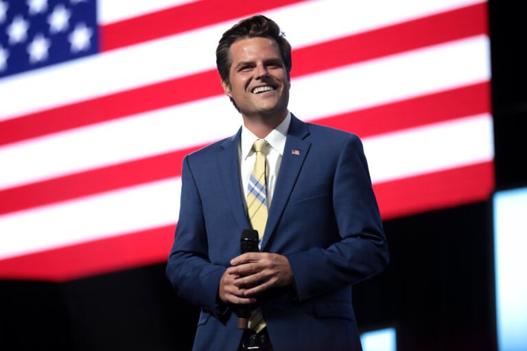 Matt Gaetz addressing an audience with a confident smile, symbolizing the highs and lows of his political journey in 'The Rise, The Fall, and What Lies Ahead.